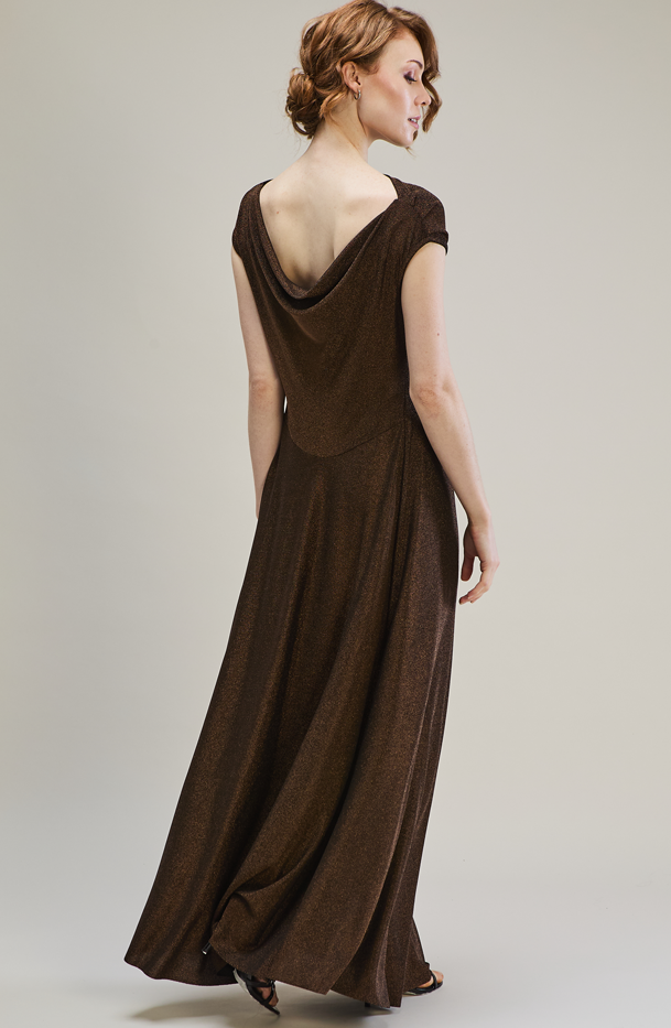 Woman wearing a brown evening gown with a draped back design on a plain background
